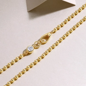 Detail of gold 925 silver beaded necklace with moissanite pendant and horseshoe clasp