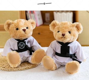 Gros plan de deux ours en peluche en uniforme de Taekwondo avec ceintures noires