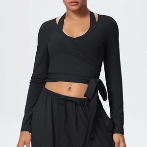 Detail of black cross-wrap yoga top with long sleeves and stylish tie-front design