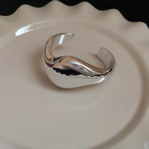 Vista dettagliata di un bracciale geometrico irregolare argento con finitura lucida