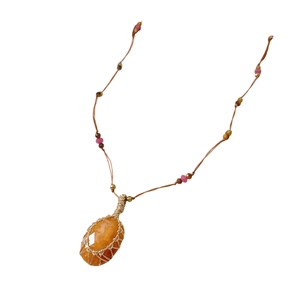 Handmade ethnic necklace featuring orange stone pendant with gold woven wire mesh