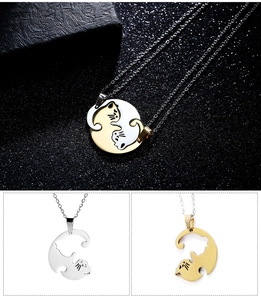 Macro detail of embracing cat pendant necklaces in gold and silver polished steel