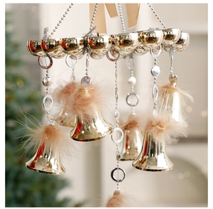 Close-up of golden Christmas bells with champagne feathers and beaded chain decor