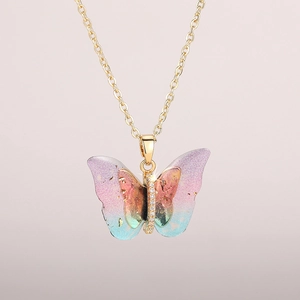 Detail of butterfly pendant necklace with gradient resin wings and gold foil accents