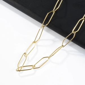 Detail of golden rectangle paperclip link chain necklace on a minimalist tray