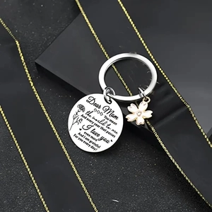 Detail of stainless steel keychain with engraved quote and pink enamel cherry blossom charm