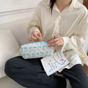 A detailed view showing the quilted texture and floral pattern of a soft stationery pouch.
