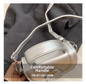 Detail of the comfortable silver metallic top handle and sturdy hardware on the crossbody bag