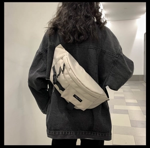 Dettaglio della borsa a tracolla in nylon beige con cinturino nero regolabile sul modello