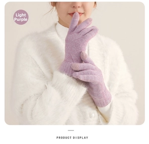 Detail of light purple knitted winter gloves with touchscreen fingertips and thick texture