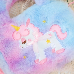 Close-up of fluffy unicorn plush bag with gradient fur and embroidered bow detail
