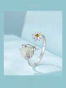 Macro view of S925 sterling silver ring with luminous firefly and daisy flower details