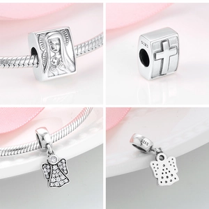 Macro view of S925 silver angel wing and religious charms showing intricate details