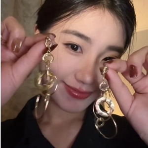 Modern gold multi-layered hollow circle tassel earrings worn in a stylish setting