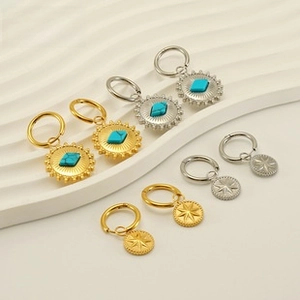 Detalle de dijes vintage de sol y estrella en acabados dorado y plateado