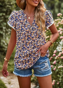 Detail of floral print V-neck top showing delicate white lace trim on the short sleeves