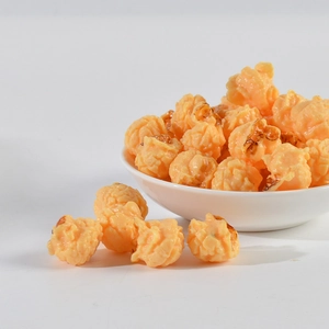 Gros plan d'un modèle de pop-corn en PVC réaliste avec texture caramel dans un bol blanc