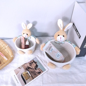 Detailed close-up of woven cotton rope baskets with plush rabbit decor and plaid bows