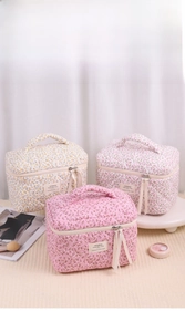 Detailed view of quilted floral makeup bags in ginger and pink with ribbon zippers