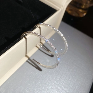 Close-up of sparkling silver circle earrings with rhinestones in a black jewelry box