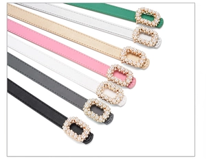 Detail of colorful faux leather belts with pearl-encrusted rectangular buckles