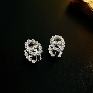 Macro shot of silver bow flower earrings with cubic zirconia in a modern pavé setting