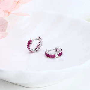 Detailed macro view of S925 sterling silver hoop earrings with red zircon stones