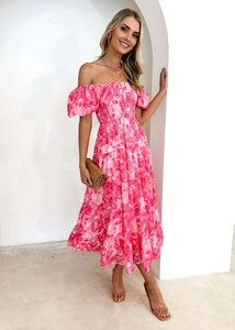Dettaglio del vestito rosa a fiori con spalle scoperte, maniche a sbuffo e balze