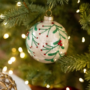Hand-painted 8cm white glass Christmas ball with red berries on a festive tree branch