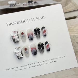 Handmade press-on nails with 3D angel reliefs, black bows, and red rose nail art patterns
