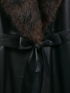 Detailed close-up of premium black leather coat with rich brown faux fur collar and belt