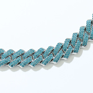 Close-up of iced out silver Cuban link chain featuring sparkling blue rhinestones