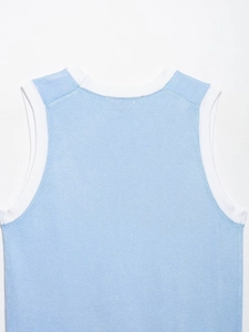 Détail d'un débardeur en maille bleu clair avec bordure blanche contrastée au col