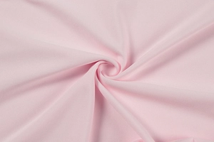 Macro detail of soft light pink dress fabric with smooth texture and graceful drape