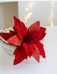 Macro detail of red velvet Christmas flower with sparkling glitter in a metal basket