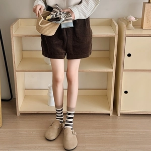 Detailed view of striped cotton mid-calf socks paired with brown corduroy shorts and clogs