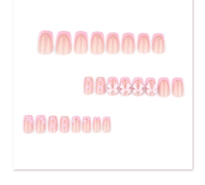 Detailed view of pink French press-on nails set with 3D bows and floral accents