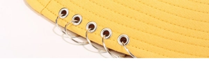 Détail du bord du chapeau bob jaune avec coutures parallèles et cinq anneaux en métal argenté