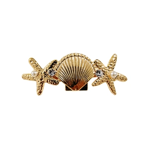 Detailed close-up of golden shell and starfish hair clip with pearls and rhinestones