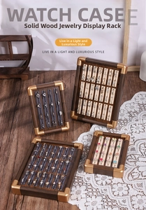Detail of walnut wood jewelry display trays with gold corners and soft velvet ring slots