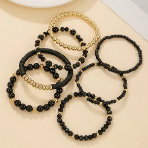 Close-up of bohemian acrylic crystal bead bracelet set with black and gold textures