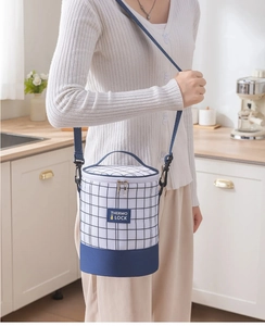 Detail of blue plaid cylindrical lunch bag with Thermo Lock label and shoulder strap