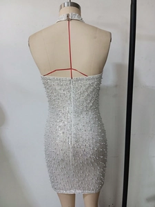 Detail of white sequin cocktail dress featuring pearl embellishments and a back zipper