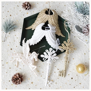 Detailed view of golden and white glitter angel wings and unicorn Christmas ornaments
