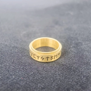 Primer plano de runas vikingas grabadas en un anillo giratorio de acero inoxidable