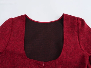 Dettaglio dell'abito in tweed bordeaux con scollo a U e cerniera invisibile