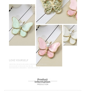 Detailed view of butterfly brooches in mint, pink, and white with pearl and gold alloy