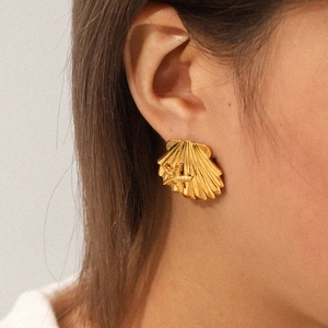 Close-up of a gold 18k stainless steel shell earring with a starfish charm on model