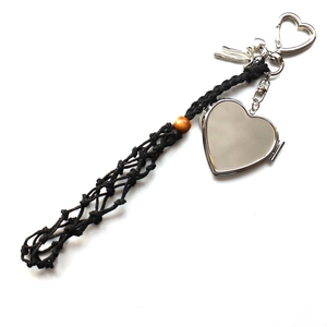 Detail of silver heart locket pendant with black hand-woven mesh net and wood bead