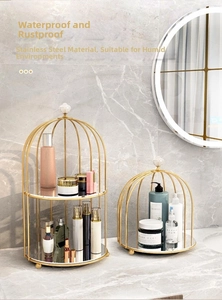 Detail of gold birdcage makeup organizer with marble tray and stainless steel frame